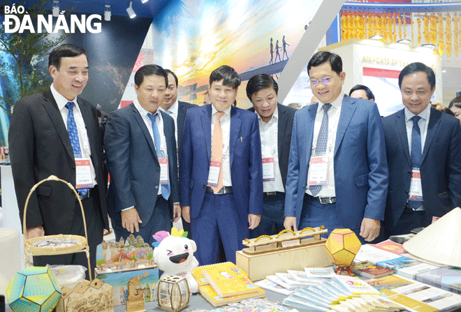 Phó Bí thư Thường trực Thành ủy Lương Nguyễn Minh Triết (thứ hai, từ trái sang), Chủ tịch UBND thành phố Lê Trung Chinh (bìa trái) và Phó Chủ tịch UBND thành phố Trần Phước Sơn (thứ hai, từ phải sang) cùng các đại biểu thăm gian hàng của Đà Nẵng tại sự kiện. Ảnh: THU HÀ