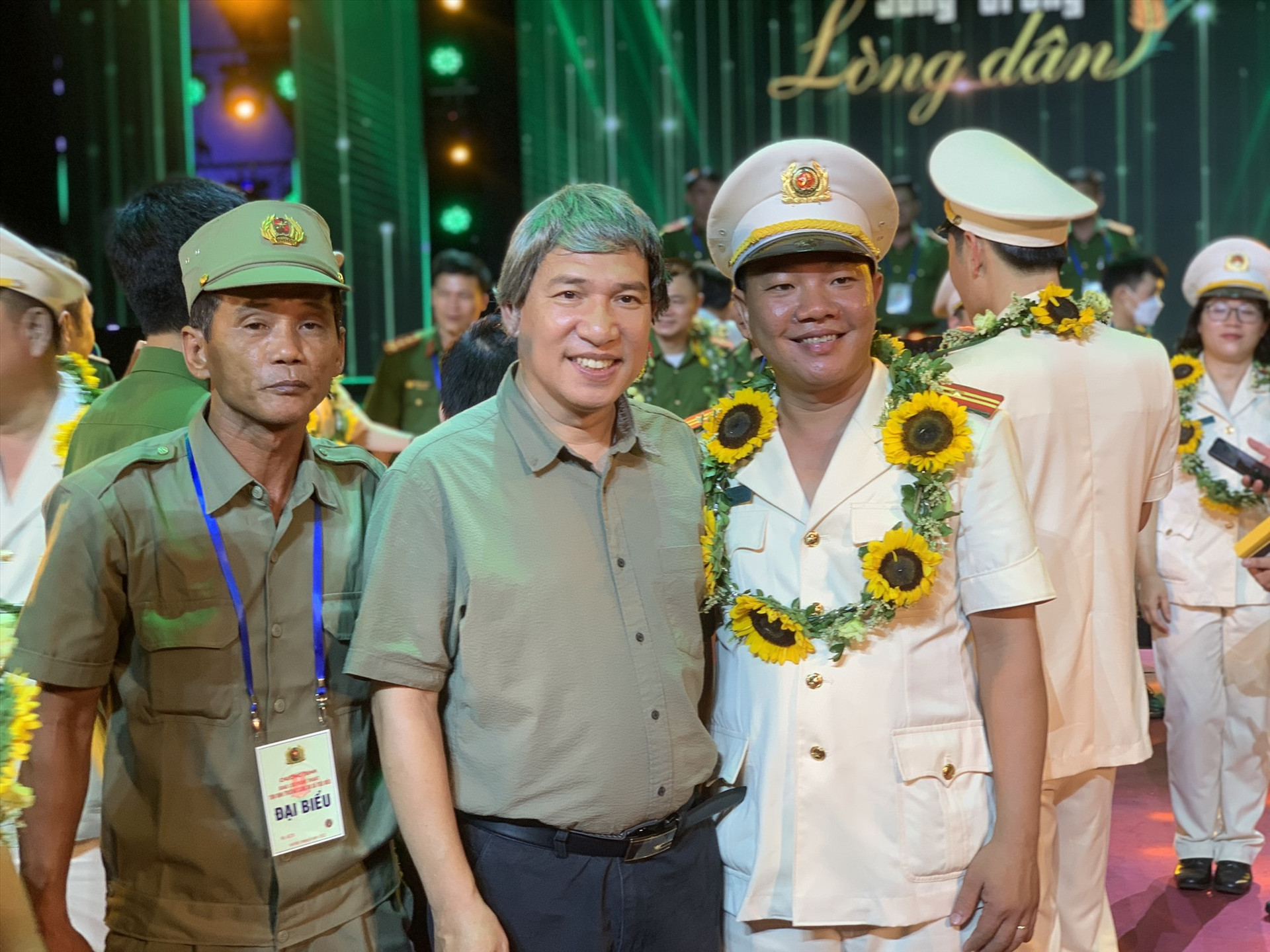 Ông Võ Văn Tâm chụp hình lưu niệm của nghệ sĩ Quang Thắng tại Chương trình tôn vinh Trưởng công an xã tiêu biểu “Sống trong lòng dân” năm 2022. Ảnh: NVCC