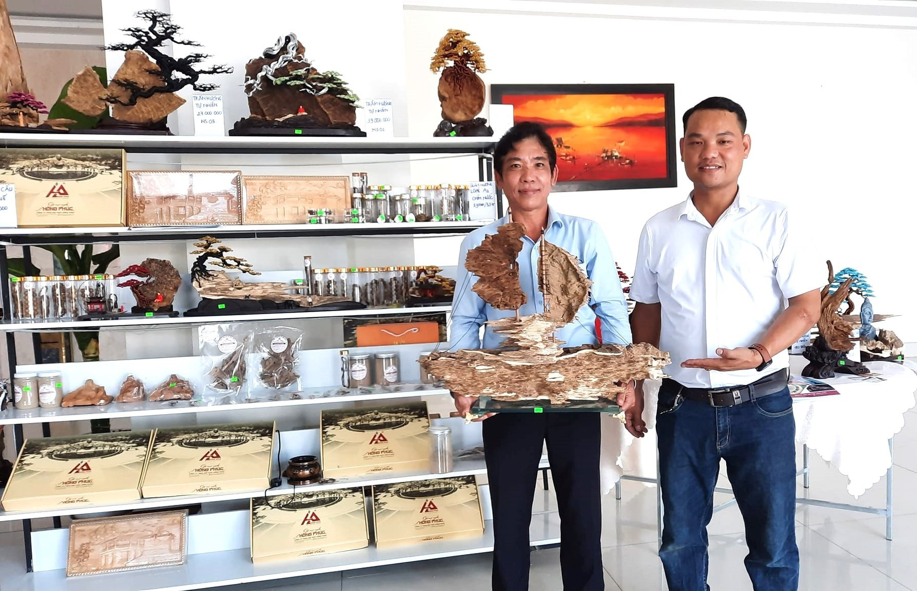 Ông Lê Hồng Thái - Giám đốc Công ty TNHH Nội thất Hồng Phúc (bên phải) giới thiệu về các sản phẩm trầm hương mỹ nghệ mới. Ảnh: H.P
