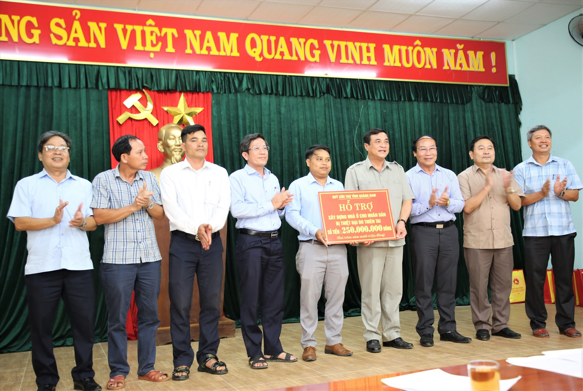 Lãnh đạo tỉnh trao số tiền tượng trưng hỗ trợ xây dựng nhà ở người dân bị thiệt hại thiên tai cho đại diện lãnh đạo xã Trà Linh. Ảnh: N.L