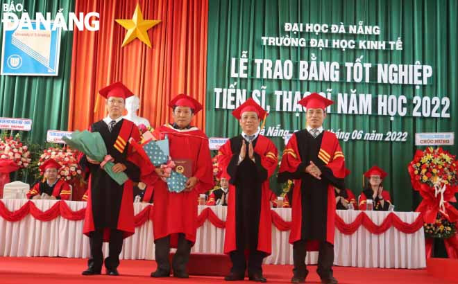 PGS. TS Nguyễn Ngọc Vũ, Giám đốc ĐH Đà Nẵng (thứ 3 từ trái sang) và lãnh đạo Trường ĐH Kinh tế trao bằng cho tân tiến sỹ (thứ 2 từ trái sang). Ảnh: NGỌC HÀ.