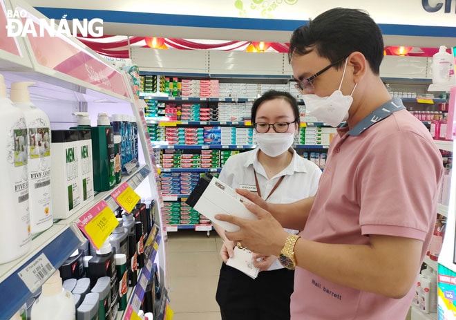 Nhân viên tư vấn một sản phẩm dầu gội cho khách hàng. Ảnh: QUỲNH TRANG