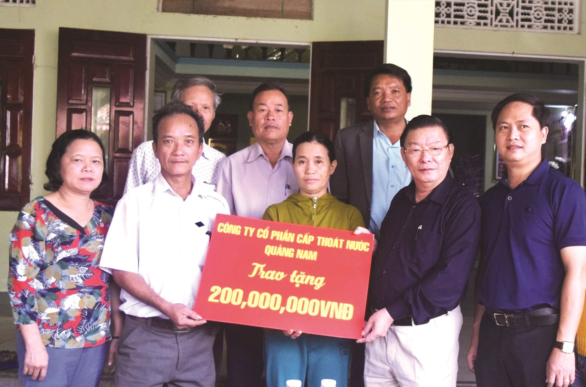 Ông Ngô Đức Trung - Chủ tịch HĐQT, Tổng Giám đốc Công ty CP Cấp thoát nước Quảng Nam (thứ hai, bên phải) trao 200 triệu đồng hỗ trợ thiệt hại do lũ lụt ở Điện Bàn.