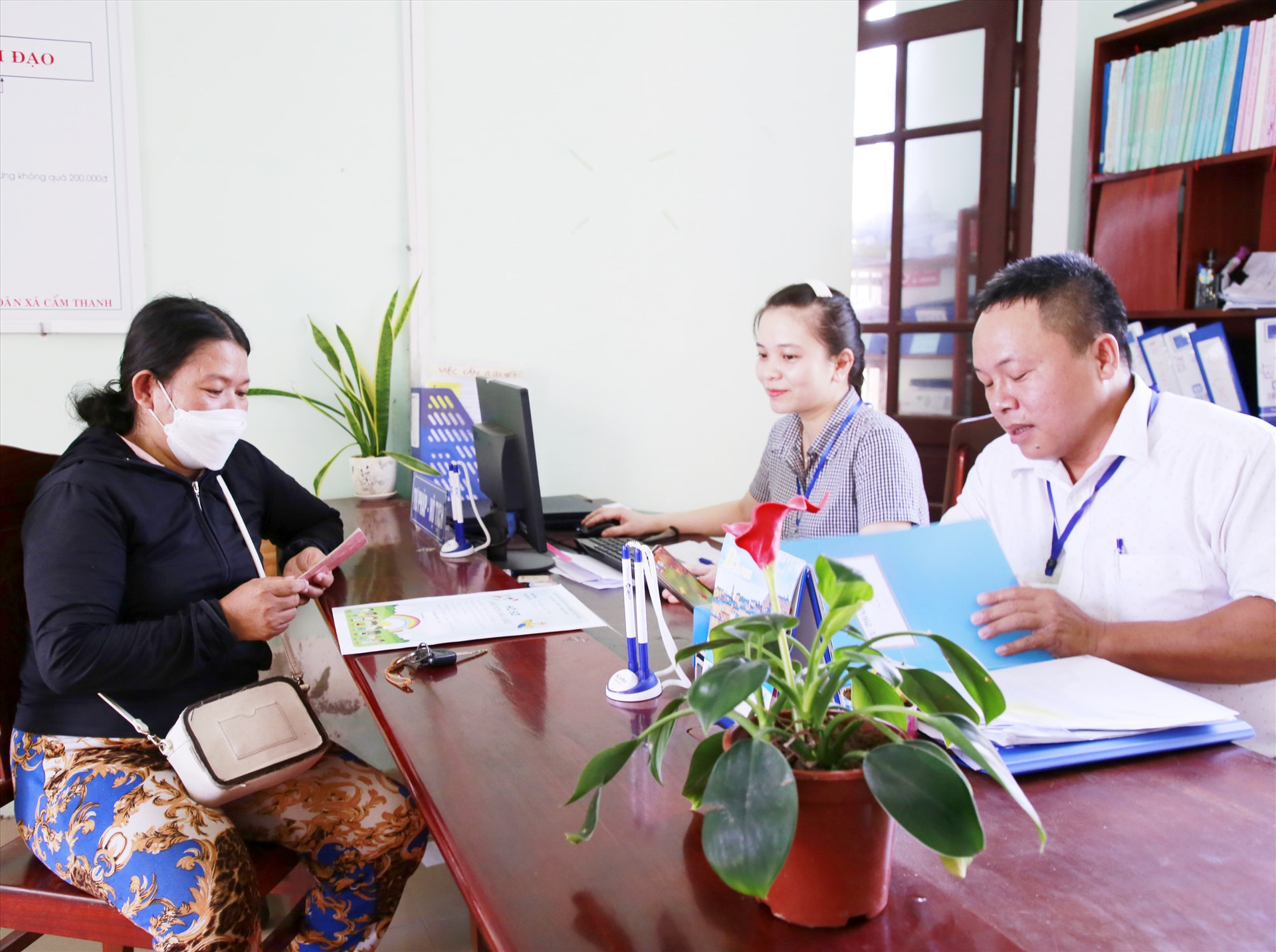 Chị Nguyễn Thị Cận chỉ mất vài phút để xác nhận, làm thủ tục nhập học cho con tại UBND xã Cẩm Thanh. Ảnh: T.C