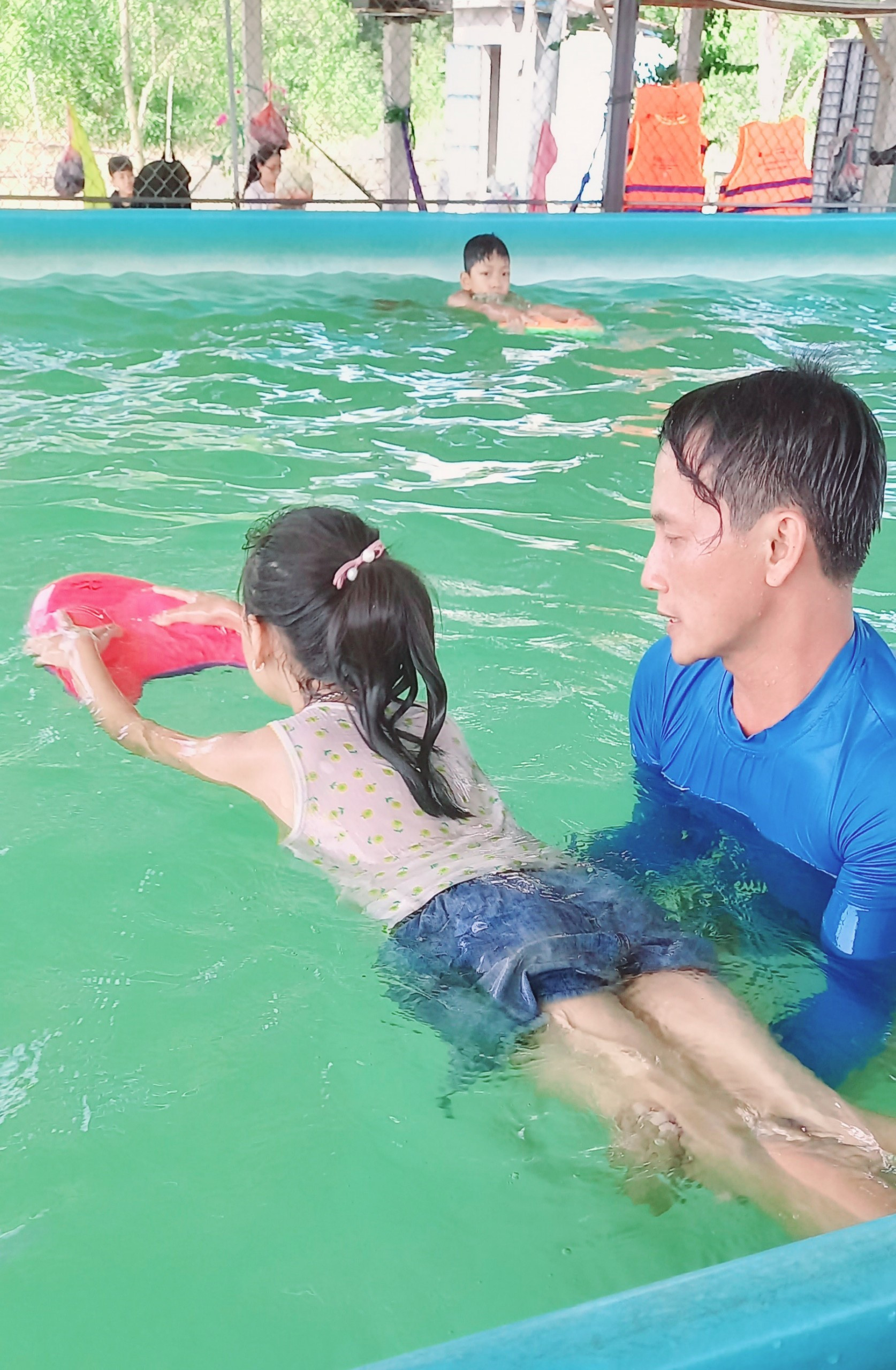 Trẻ em được huấn luyện viên hướng dẫn kỹ năng bơi. Ảnh: M.T