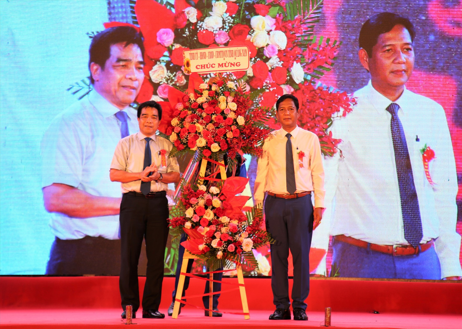 Chủ tịch UBND huyện Nam Giang - A Viết Sơn (bên phải) đón nhận lẵng hoa chúc mừng từ Thường trực Tỉnh ủy. Ảnh: A.N
