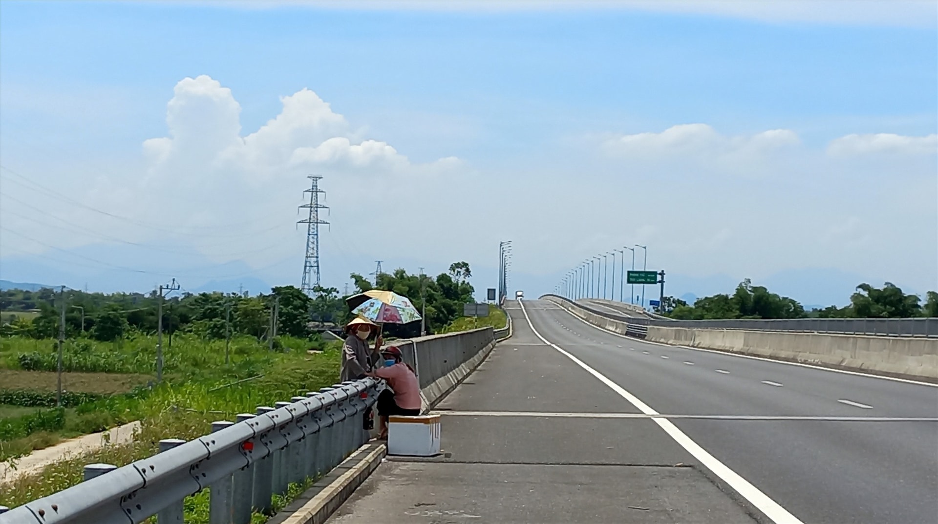 Người dân “vô tư” lên cao tốc Đà Nẵng - Quảng Ngãi, đoạn qua Điện Bàn, ngồi chờ đón xe gửi hàng. Ảnh: T.C.T