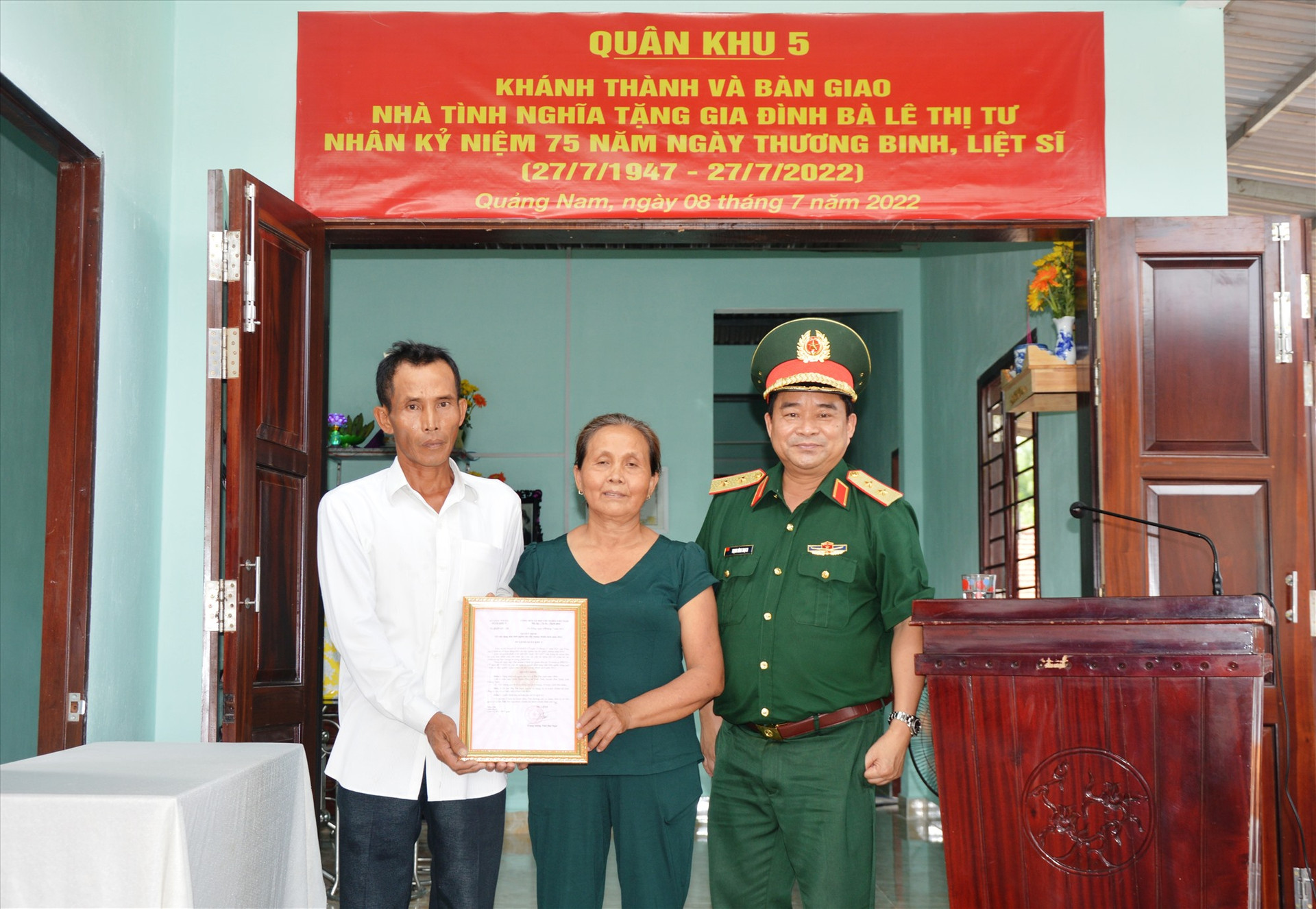 Trung tướng Trịnh Đình Thạch, Chính ủy Quân khu 5 trao quyết định bàn giao nhà cho gia đình bà Lê Thi Tư hiện sống tại xã Tam Thái, huyện Phú Ninh.