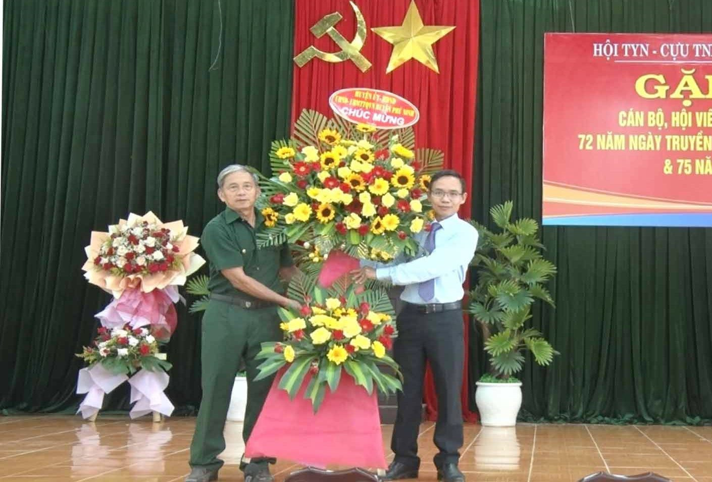 Chủ tịch UBND huyện Phú Ninh Huỳnh Xuân Chính tặng hoa chúc mừng kỷ niệm 72 năm Ngày truyền thống lực lượng Thanh niên xung phong Việt Nam. Ảnh: Đ.V
