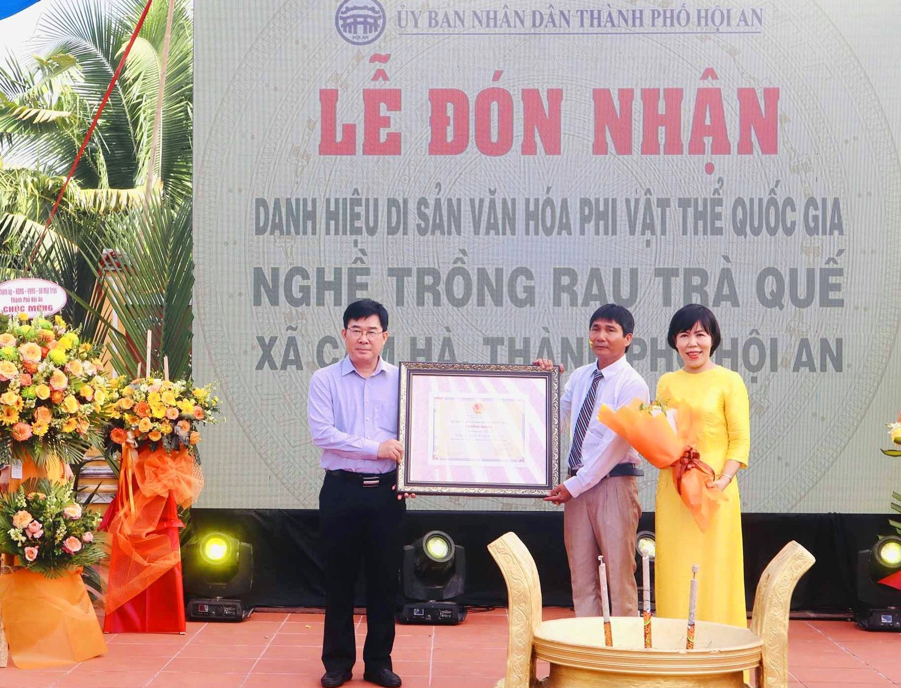 Đại diện lãnh đạo Cục Di sản văn hóa, Bộ VH-TT&DL (bên trái) trao bằng chứng nhận di sản văn hóa phi vật thể quốc gia cho Nghề trồng rau Trà Quế. Ảnh: Q.T