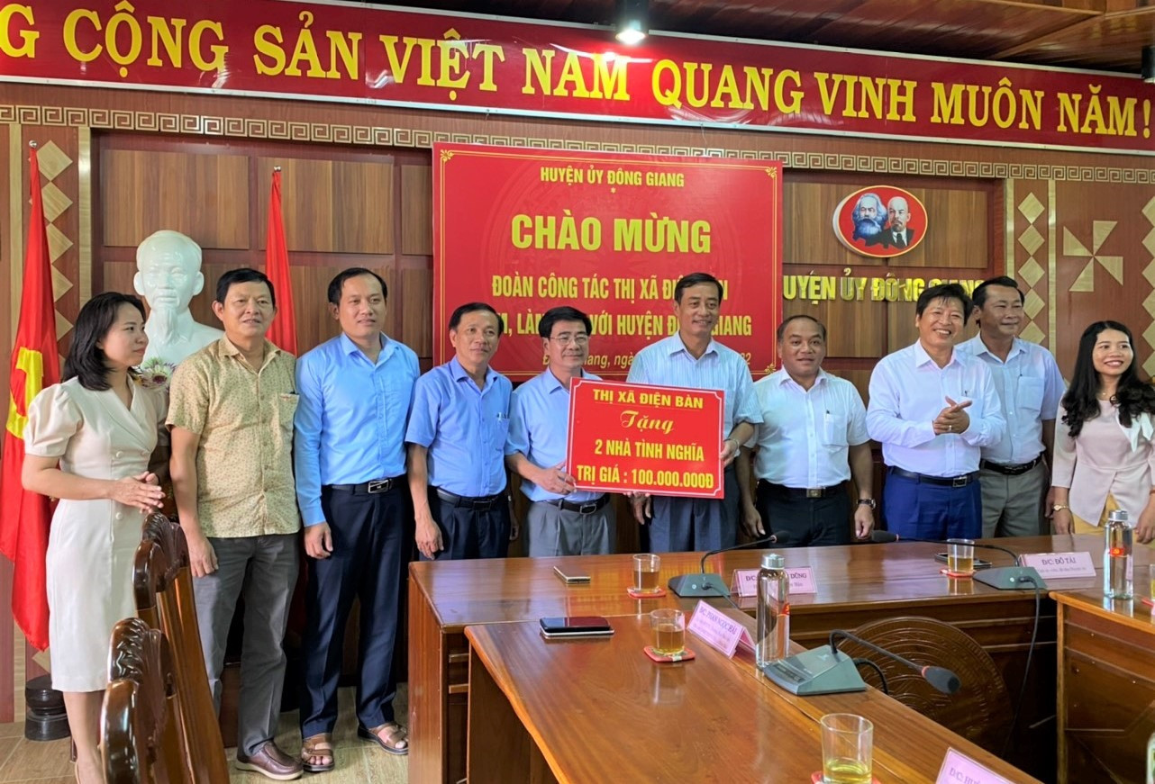 Đại diện lãnh đạo thị xã Điện Bàn trao bảng tượng trưng hỗ trợ 2 nhà tình nghĩa cho người có công huyện Đông Giang. Ảnh: A.N