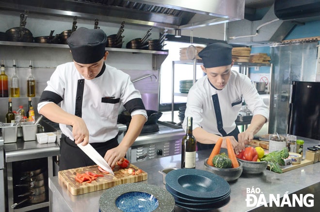 Nhiều lao động nâng cao chuyên môn nghiệp vụ của mình khi quay trở lại với công việc. Trong ảnh: Đầu bếp Đoàn Văn Cường (trái) và đồng nghiệp đang chuẩn bị bữa ăn cho khách. Ảnh: THU HÀ