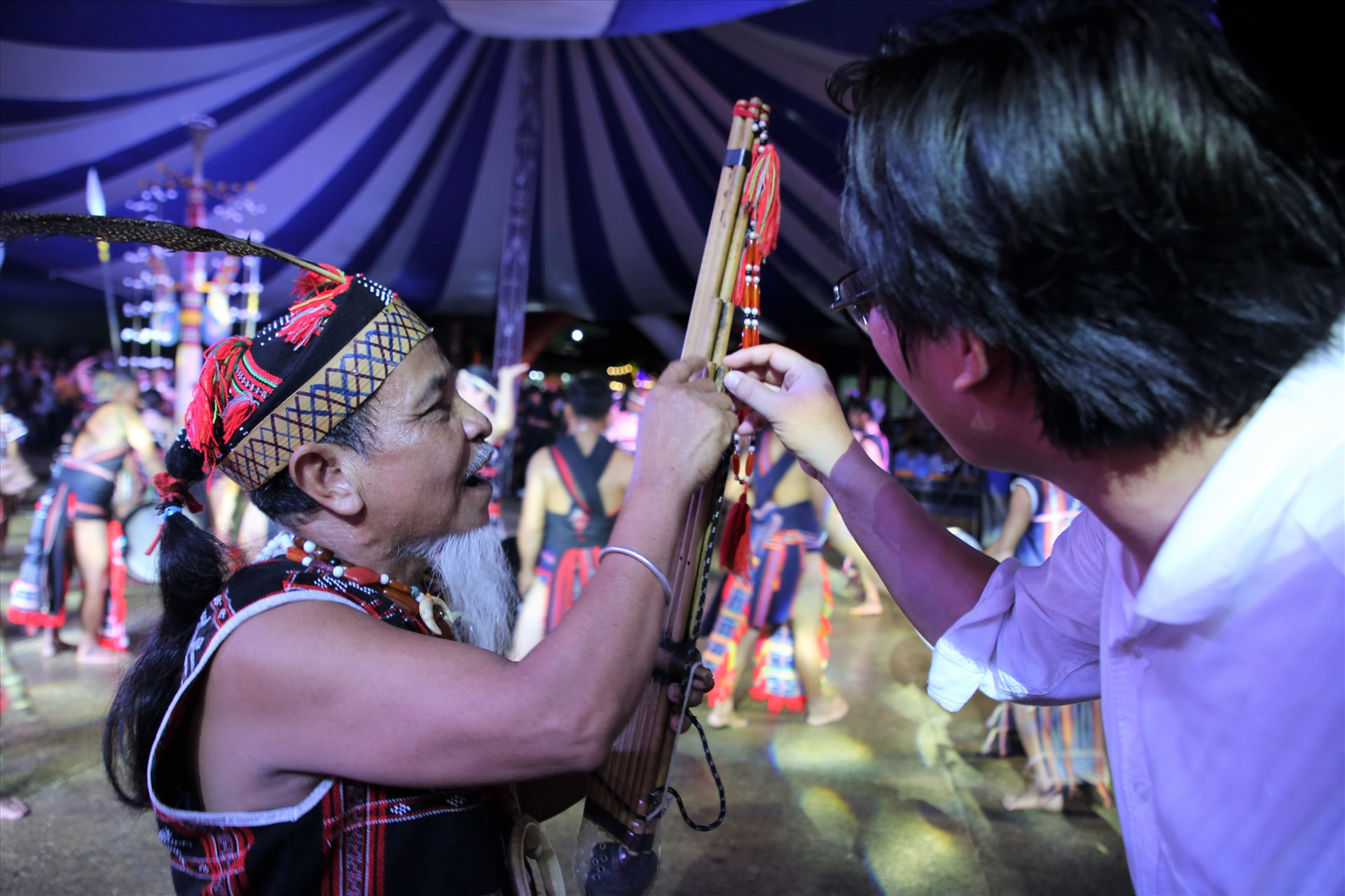 Một già làng Cơ Tu giới thiệu nhạc cụ truyền thống với du khách. Ảnh: A.N
