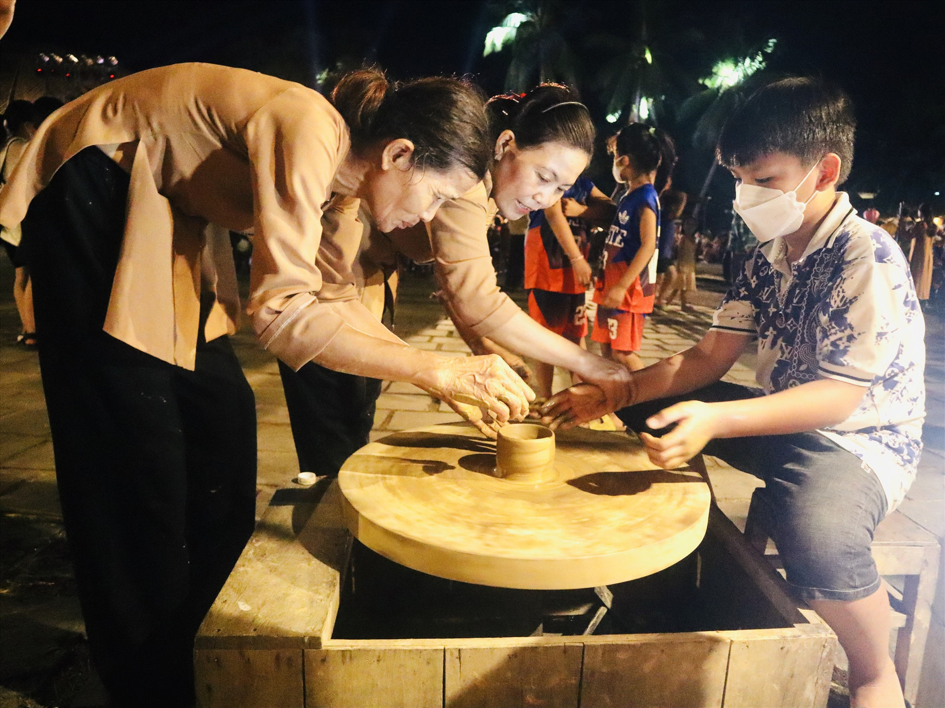 Trẻ em trải nghiệm làm gốm tại chương trình “Nét hoa nghề Hội An”. Ảnh: Q.T