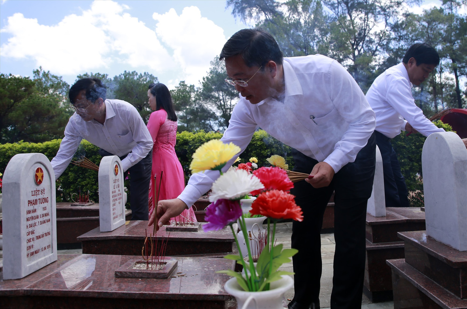 Đồng chí Lê Trí Thanh cùng các đại biểu thắp hương tại các phần mộ liệt sĩ trong khuôn viên nghĩa trang. Ảnh: T.C
