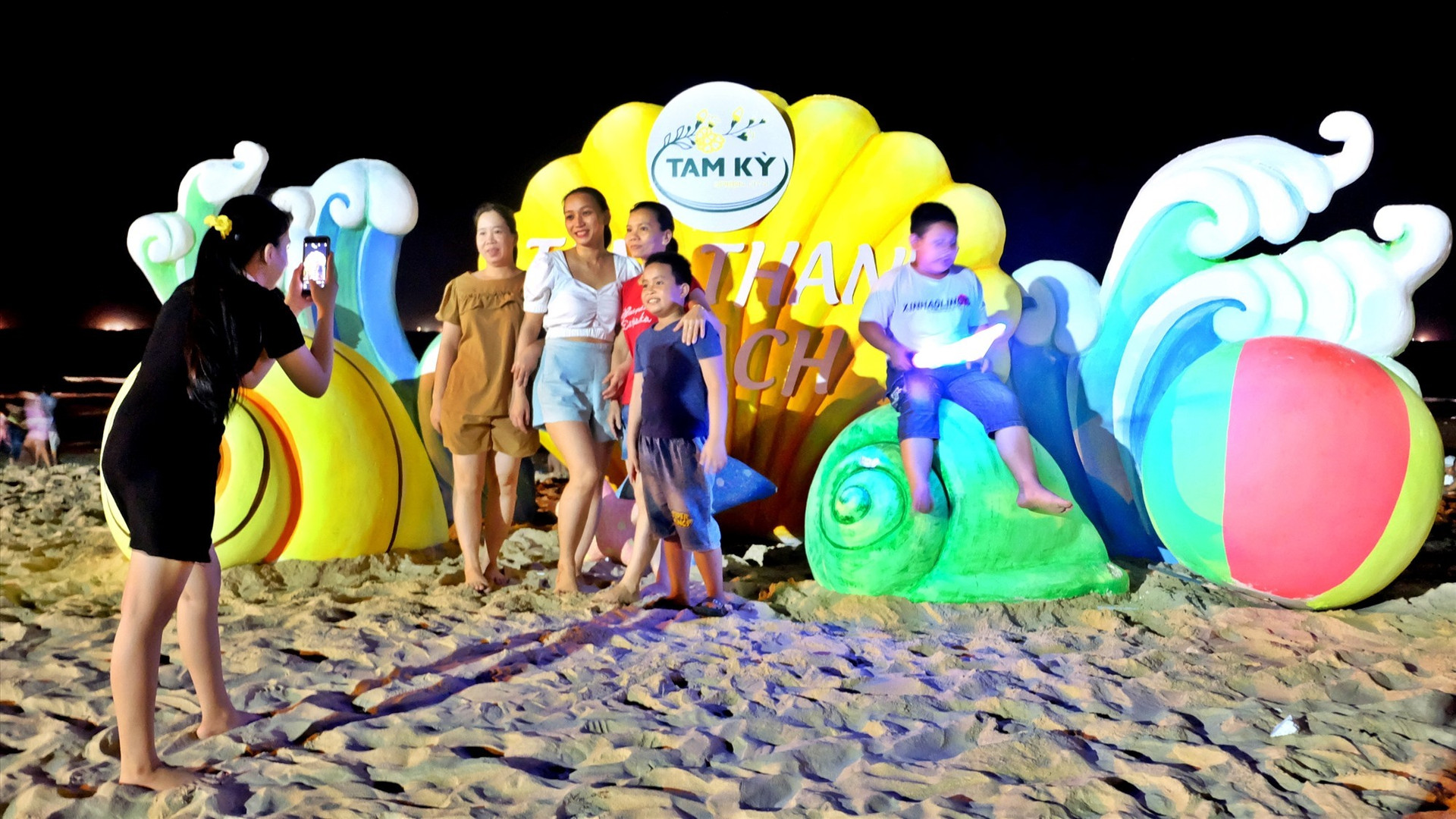 Tourists take souvenir photos at Tam Thanh beach.