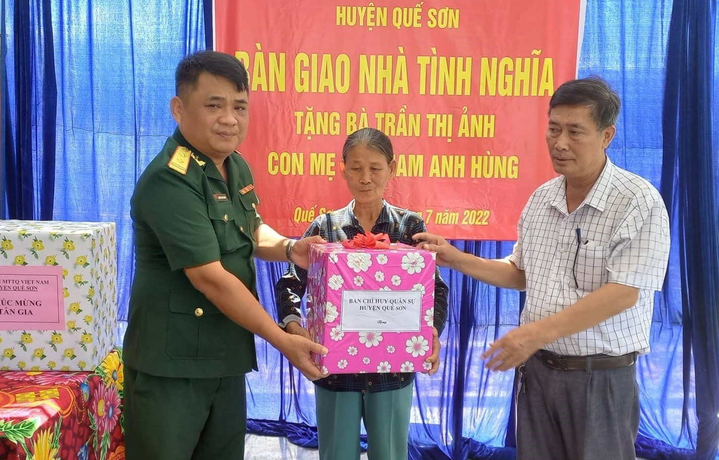 Ban Chỉ huy quân sự và Ủy ban MTTQ Việt Nam huyện Quế Sơn tặng quà cho bà Trần Thị Ảnh nhân lễ bàn giao nhà. ảnh DT