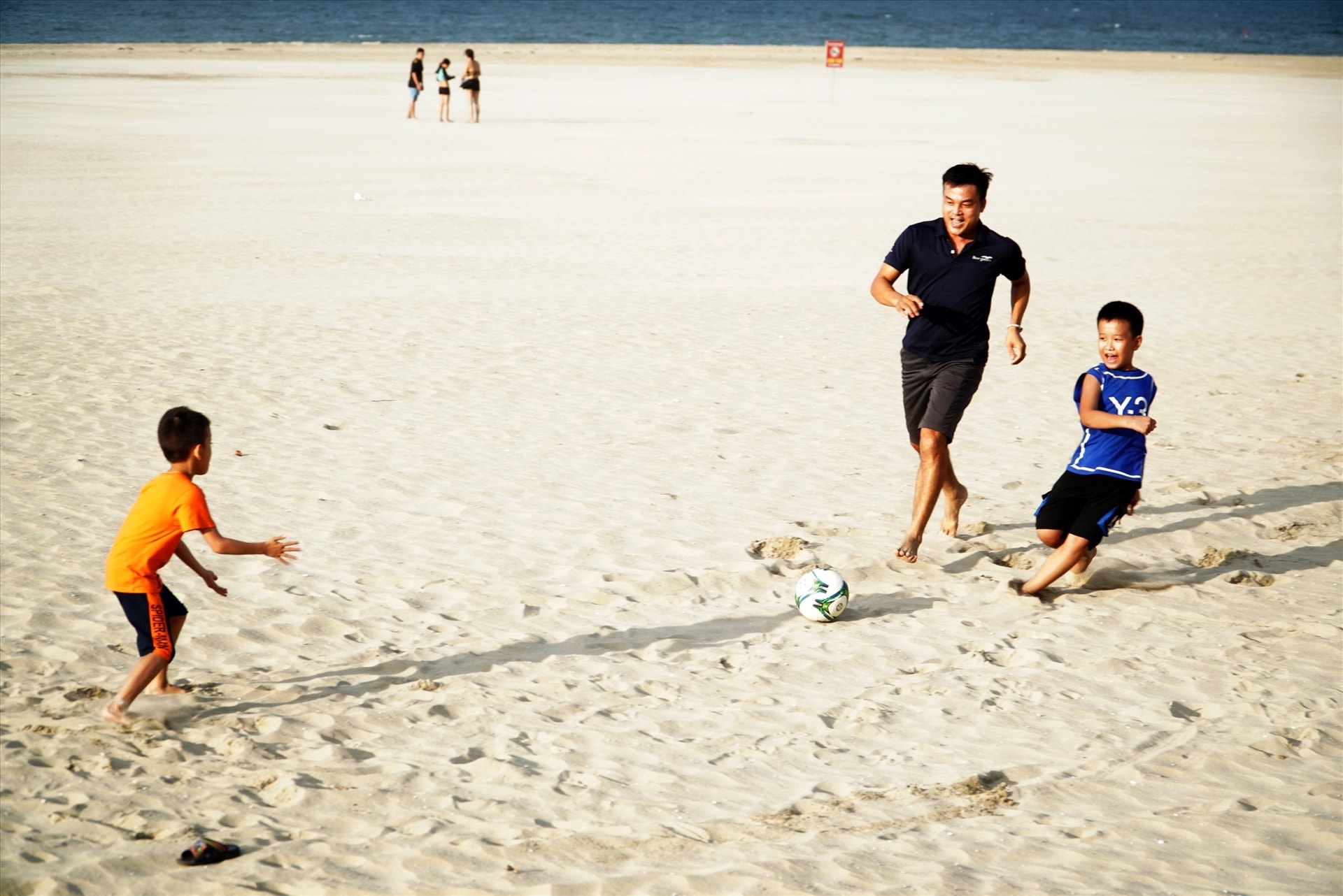 Children playing football on the restored beach