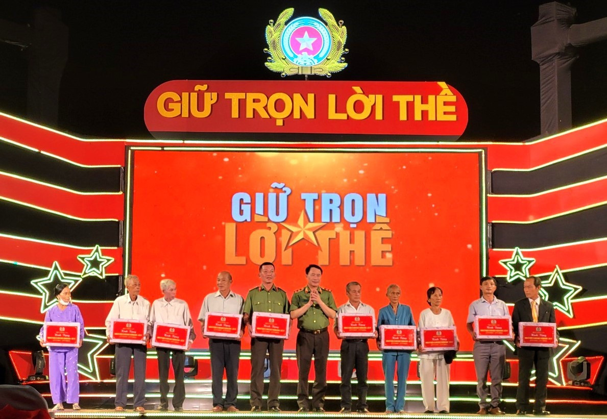 Trung tướng Lê Quốc Hùng trao quà tặng gia đình người có công cách mạng tại huyện Bắc Trà My. Ảnh: V.A