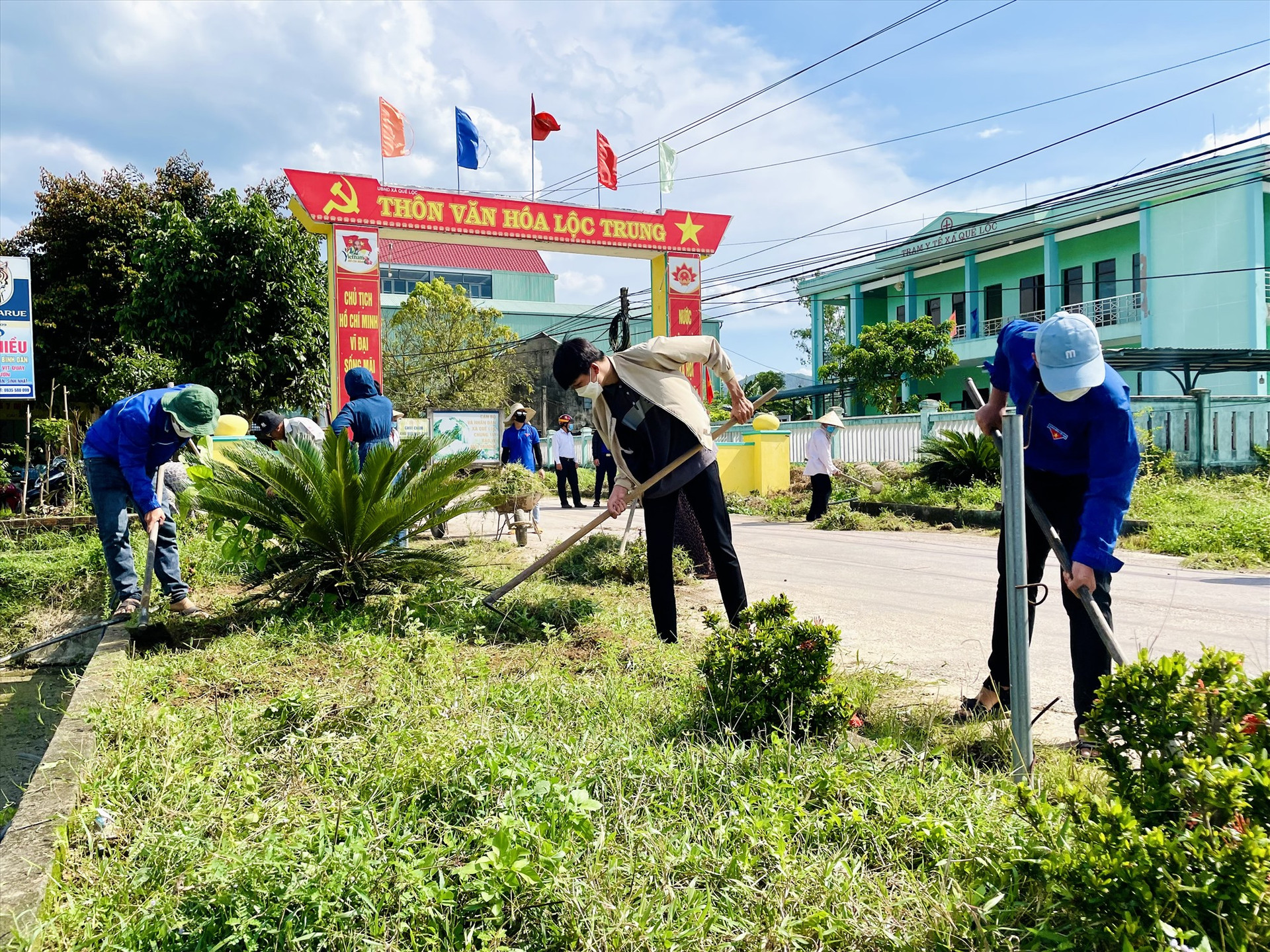 Đoàn viên, thanh niên xã Quế Lộc dọn vệ sinh, trồng hoa trên tuyến đường chính vào thôn Lộc Trung. Ảnh: TÂM THÔNG