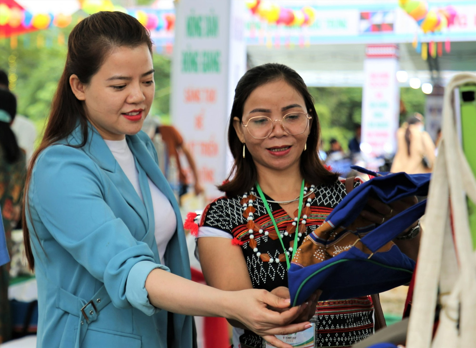 Chị Alăng Thị Oanh giới thiệu sản phẩm thổ cẩm cho du khách tại hội chợ triển lãm miền núi. Ảnh: ĐĂNG NGUYÊN