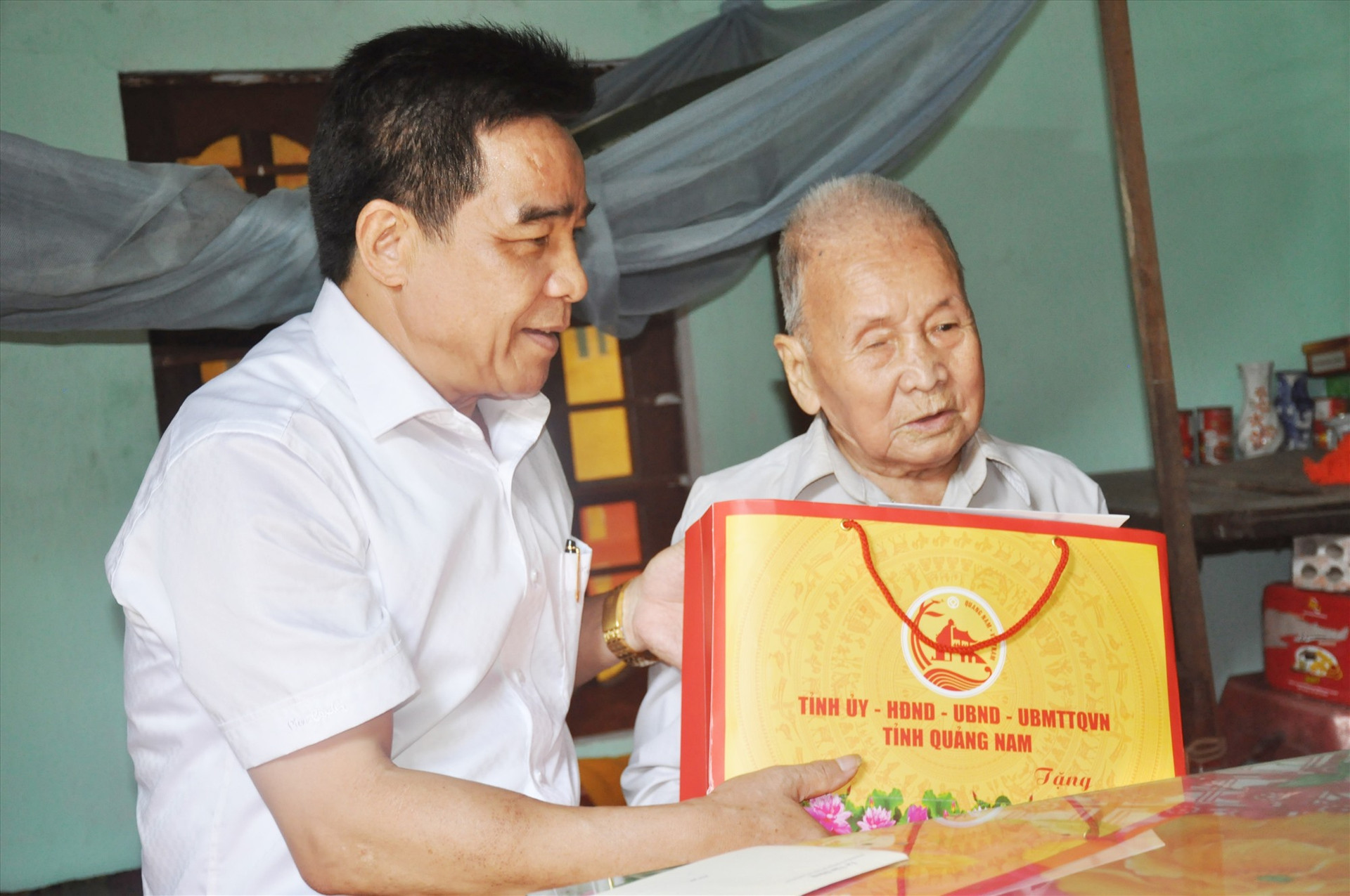 Đồng chí Lê Văn Dũng đến thăm, tặng quà cựu chiến bi Hồ Quảng - đối tượng người có công xã Quế Phong (Quế Sơn). Ảnh: N.Đ