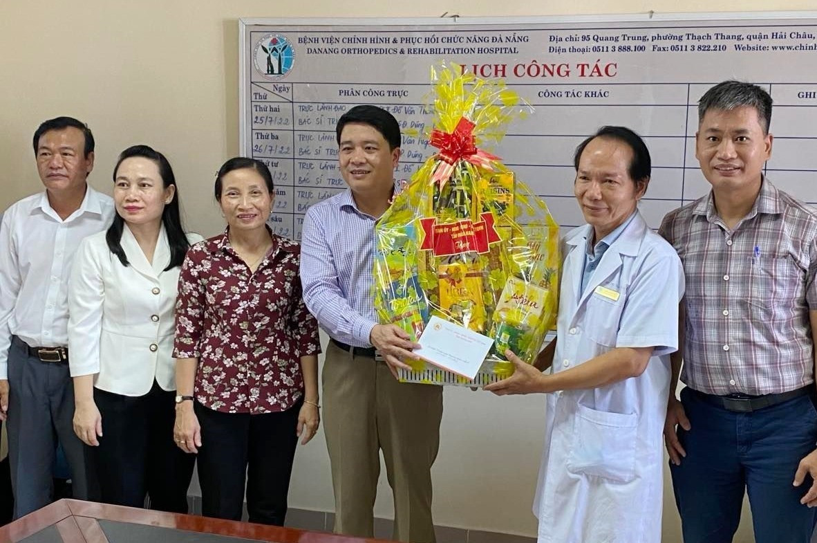 Tặng hoa cảm ơn đại diện lãnh đạo Bệnh viện Chỉnh hình và Phục hồi chức năng, Bộ LĐ-TB&XH tại Đà Nẵng. Ảnh: K.L