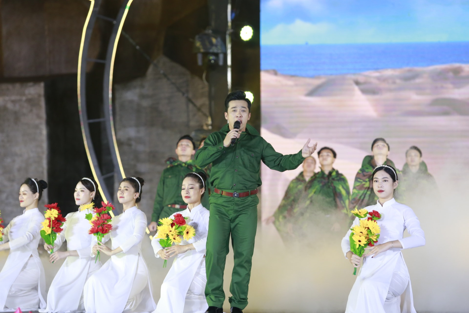 Ca sĩ Quang Hào trình diễn ca khúc “Vết chân tròn trên cát“. Phần trình diễn có sự tham gia của nhiều cựu binh Quảng Nam.