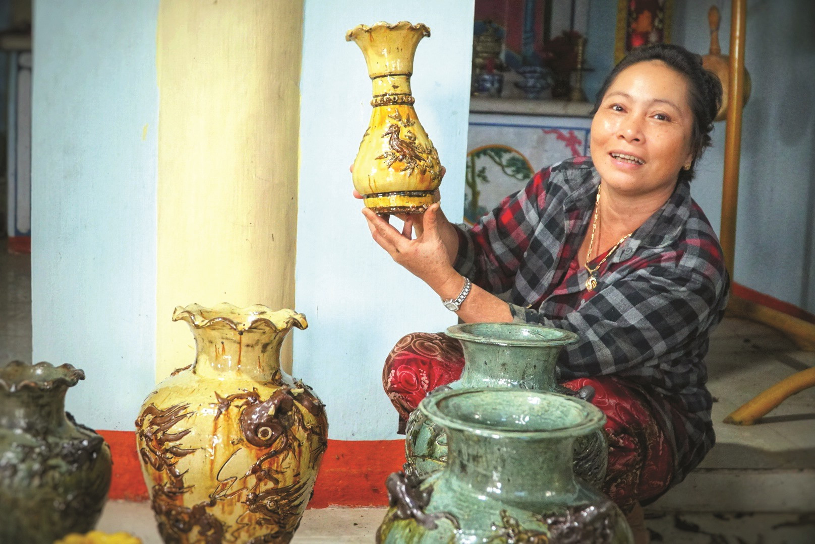 Bà Phạm Thị Cúc (vợ ông Trịnh) với các sản phẩm gốm của vợ chồng. Ảnh: TRẦN ĐĂNG