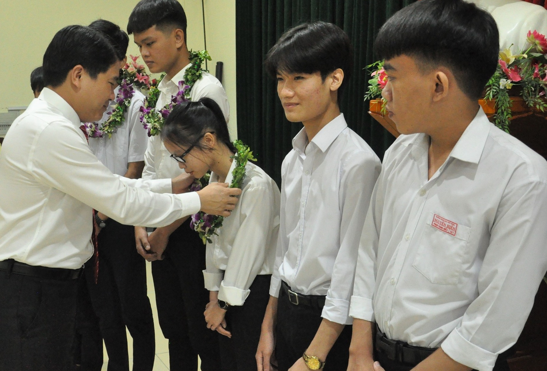 Phó Chủ tịch UBND tỉnh Trần Văn Tân tặng hoa chúc mừng các em học sinh. Ảnh: X.P