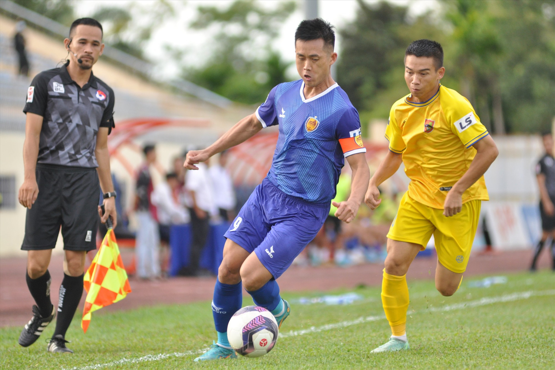 Đội trưởng Minh Tuấn (áo xanh) tran bóng quyết liệt với cầu thủ Đắc Lắc. Ảnh: T.V