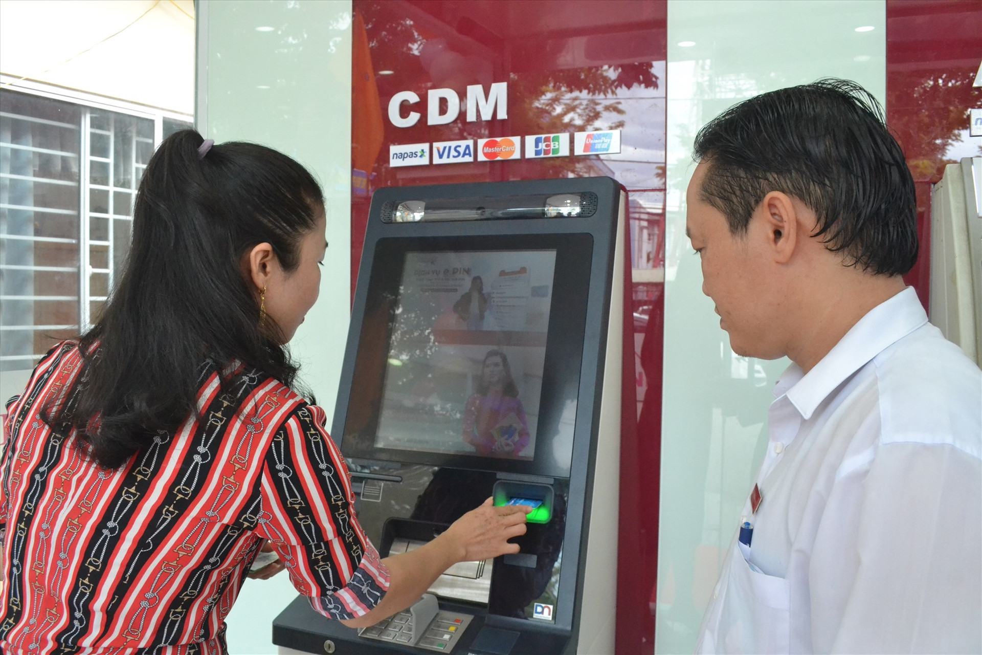 Khách hàng của Agribank Tiên Phước giao dịch tại máy gửi, rút tiền tự động AutoBank CDM. Ảnh: Q.VIỆT