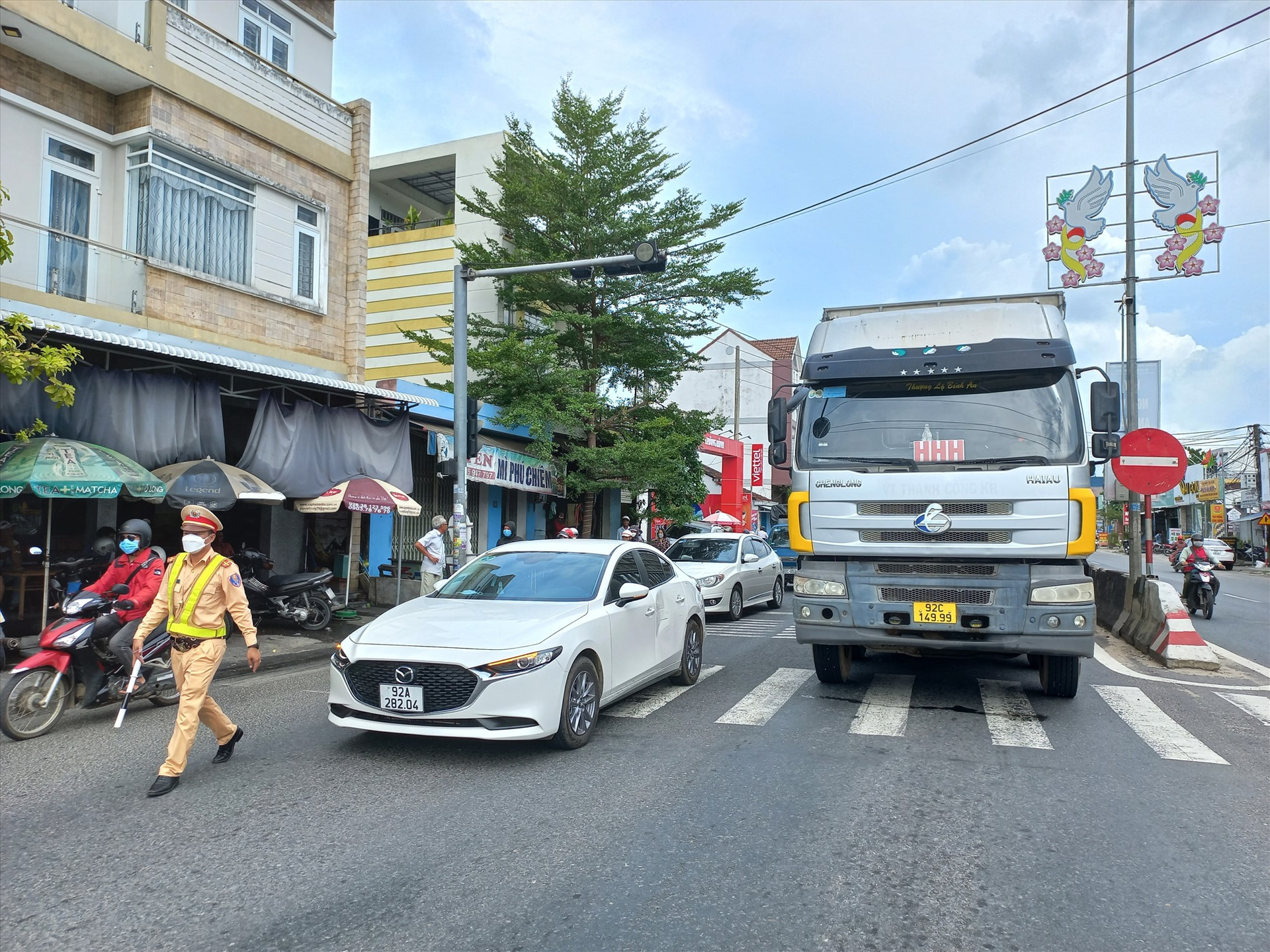 Cảnh sát giao thông phân luồng phương tiện lưu thông nhằm tránh ùn tắc trên quốc lộ 1 qua Hà Lam (Thăng Bình). Ảnh: T.C.T