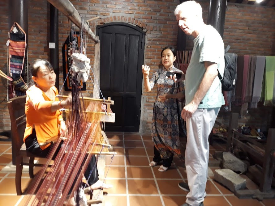 Khách nước ngoài tìm hiểu về nghề ươm tơ dệt lụa tại làng Lụa Quảng Nam. Ảnh: C.N