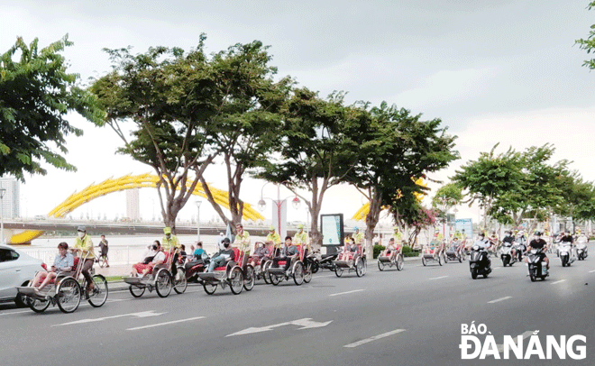 Khách du lịch quốc tế dạo chơi bằng xích lô trên đường Bạch Đằng. (Ảnh chụp ngày 4-8) Ảnh: THU HÀ
