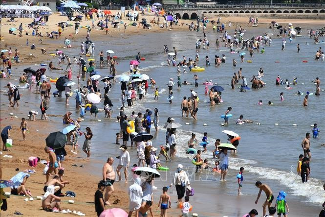 Bãi biển ở Trung Quốc đông nghẹt người vì nắng nóng. Ảnh: Xinhua