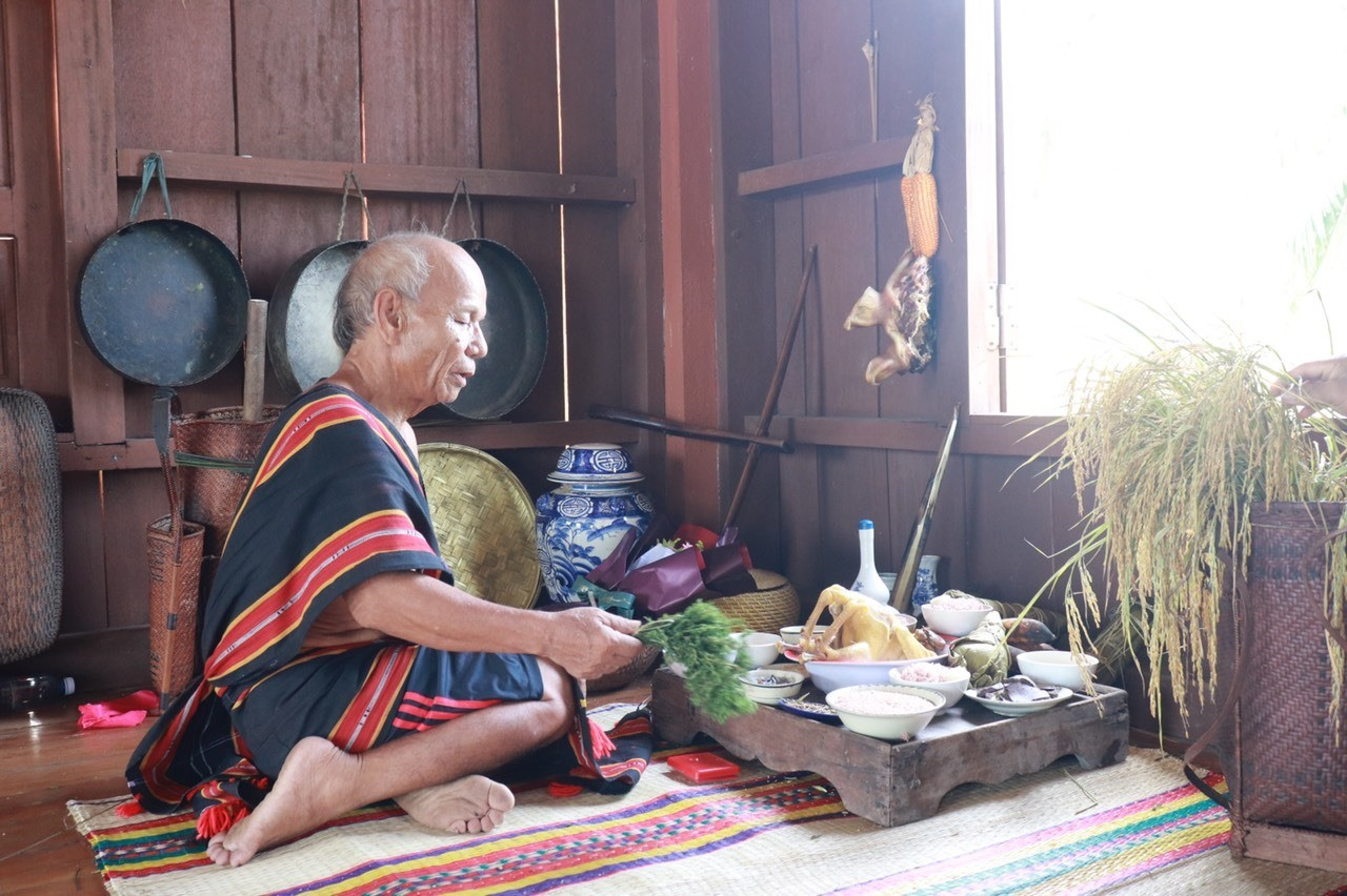 Già làng Hồ Thanh Hùng - người tộc Ca Dong đang thực hiện nghi lễ cúng lúa mới tại Nhà truyền thống. Ảnh: D.H