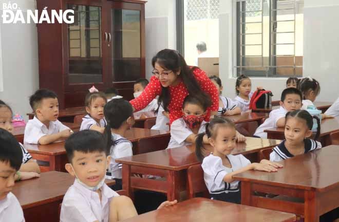 Giáo viên động viên học sinh trong buổi đầu đến lớp. Ảnh: NGỌC HÀ
