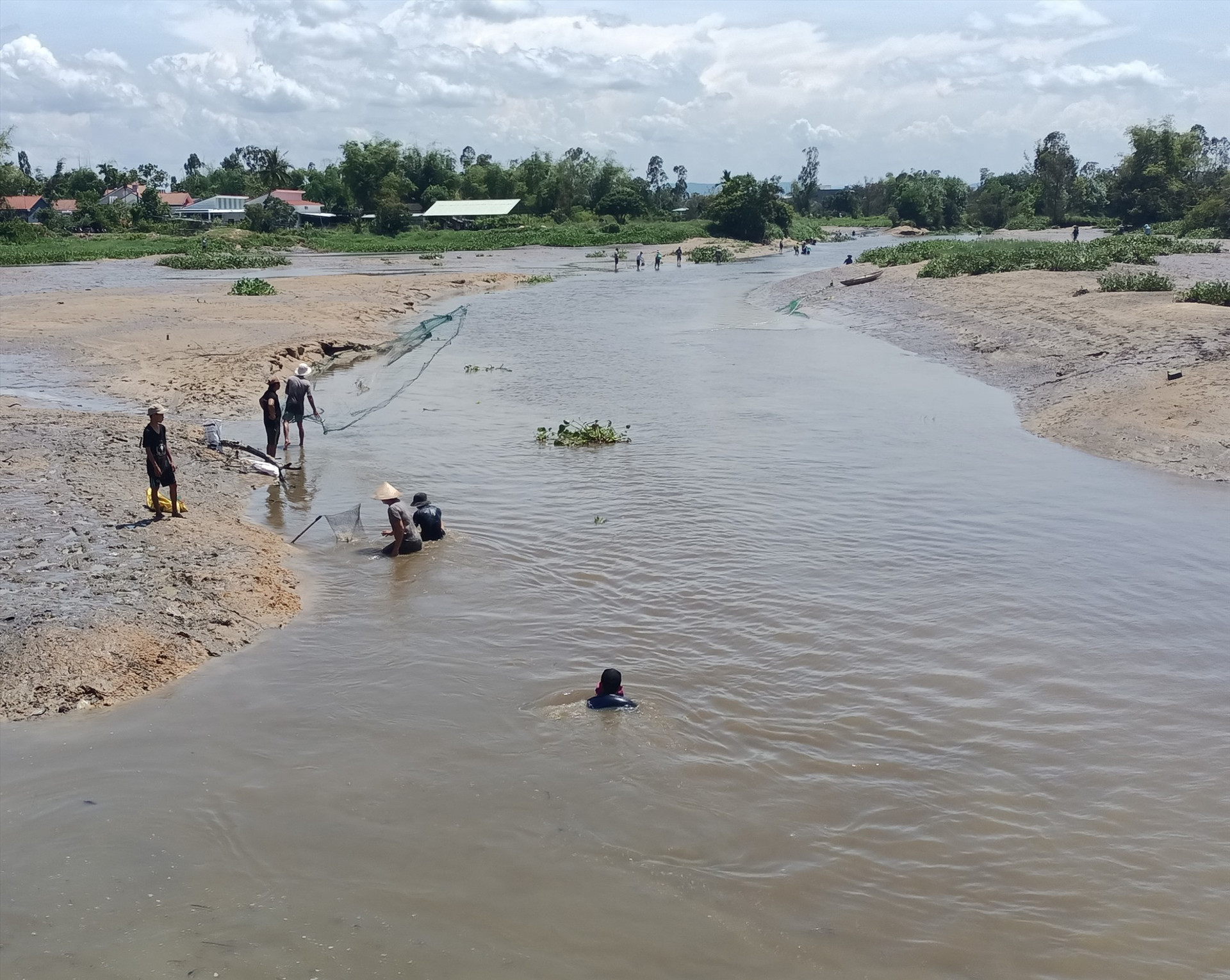 Hàng chục người dân xã Bình Phục lội bùn bắt cá ở đập Bình Hiệp. Ảnh: N.Q