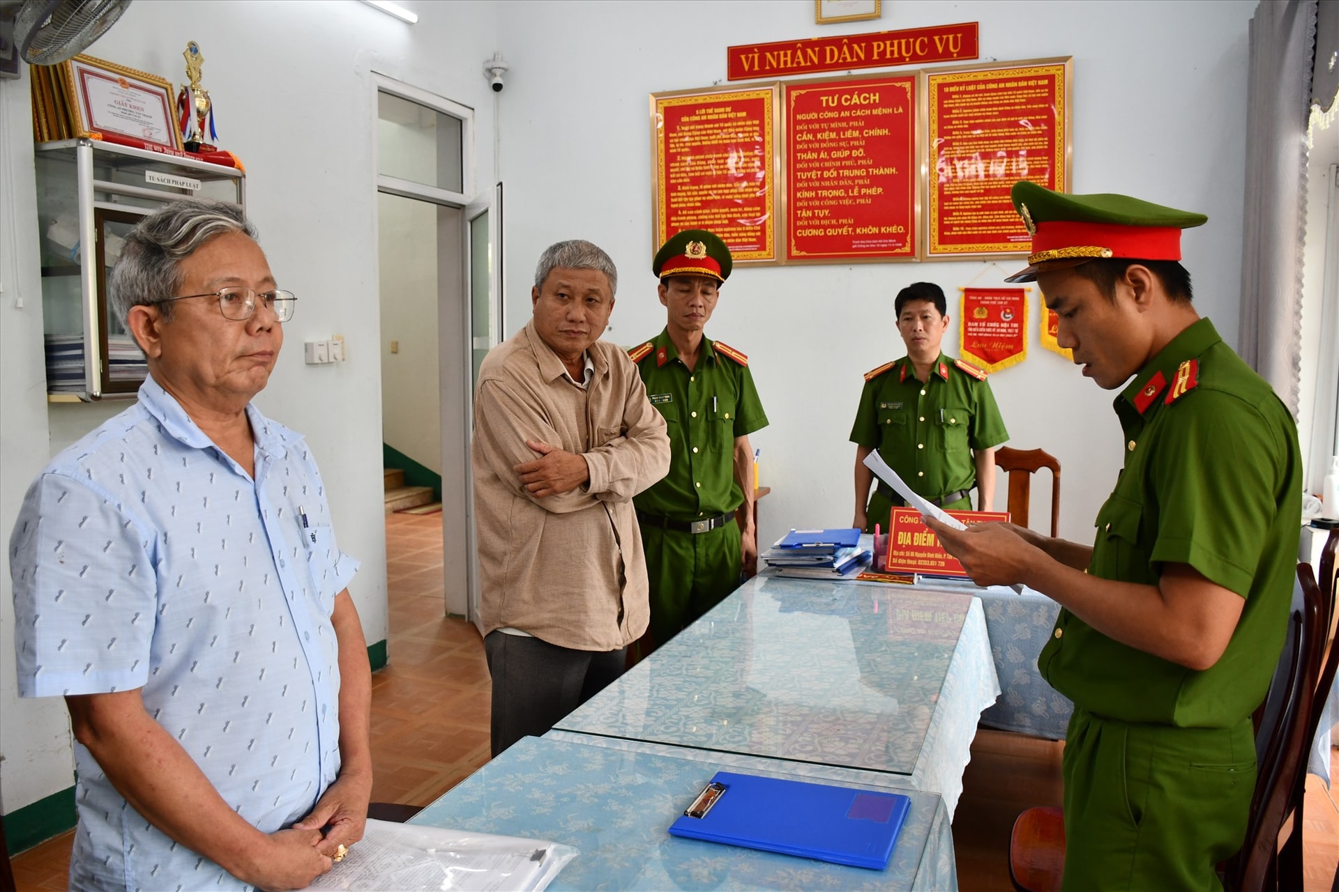 Công an đọc quyết định khởi tố đối với hai bị can. Ảnh: M.T