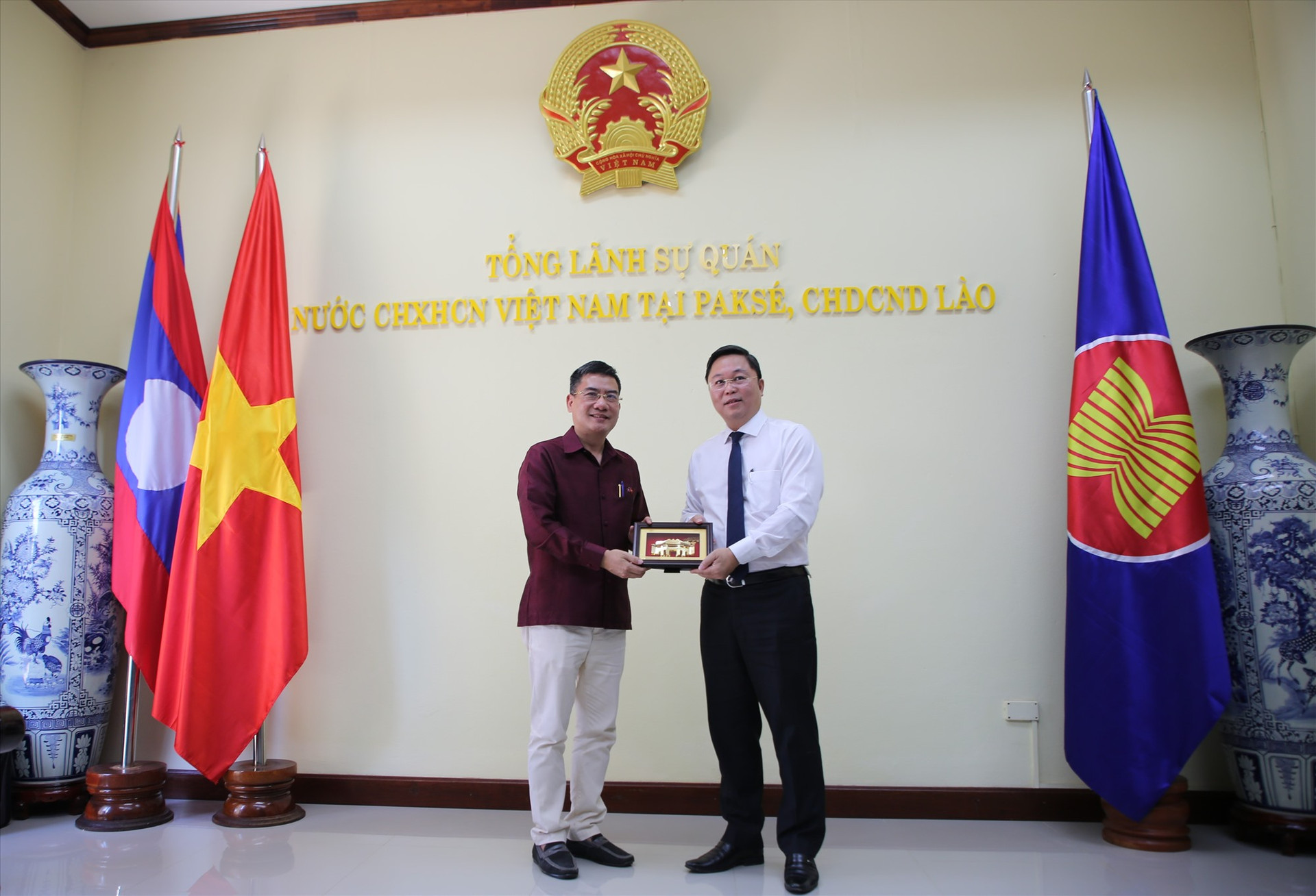 Đồng chí Lê Trí Thanh trao món quà cho đại diện Tổng Lãnh sự quán Việt Nam tại Păk Sế. Ảnh: A.N