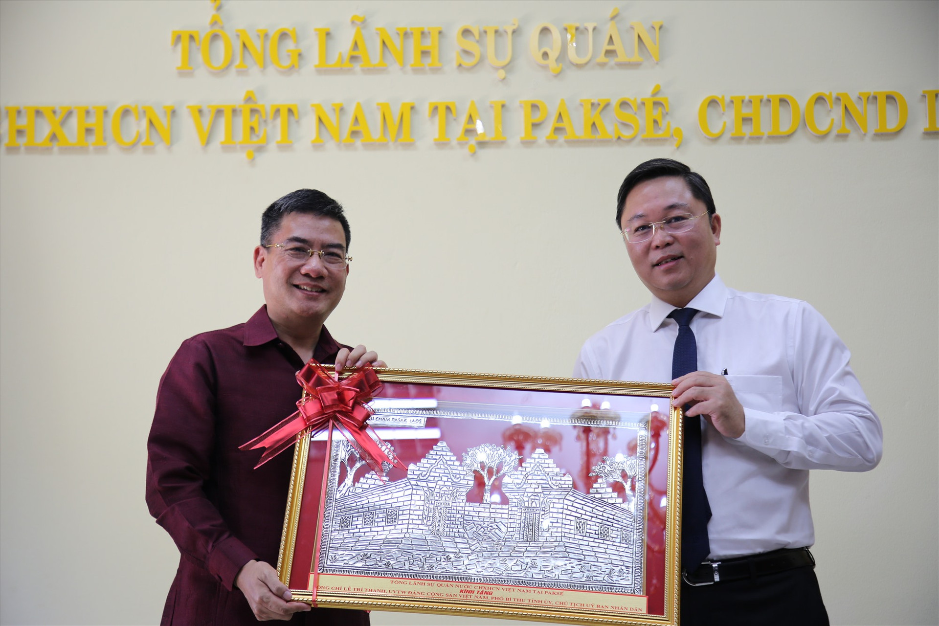 Đồng chí Nguyễn Văn Trung - Tổng Lãnh sự quán Việt Nam tại Păk Sế (trái) tặng món quà cho đoàn công tác tỉnh Quảng Nam. Ảnh: A.N
