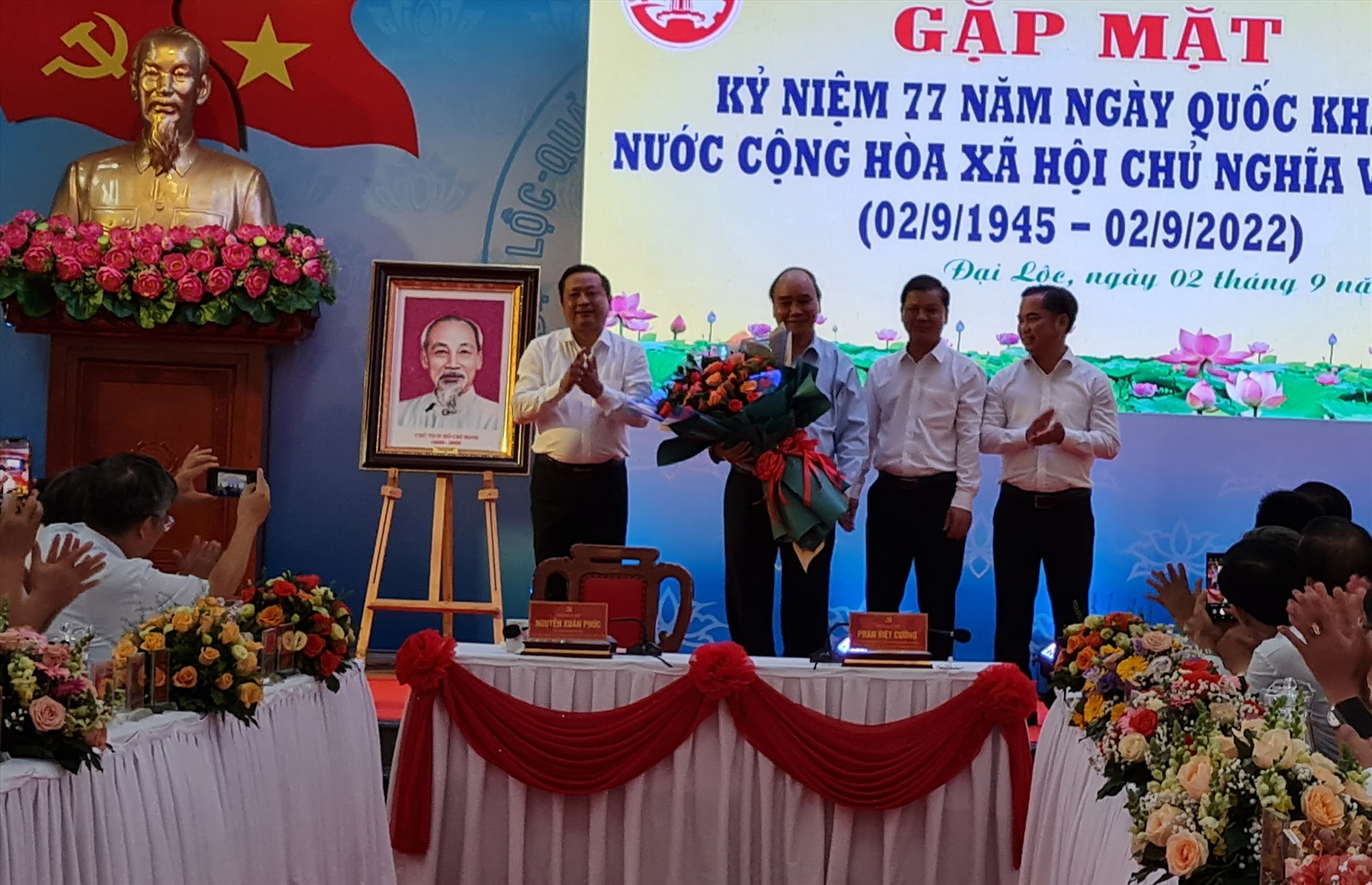 Lãnh đạo huyện Đại Lộc tặng hoa cho Chủ tịch nước Nguyễn Xuân Phúc. Ảnh: HOÀNG LIÊN