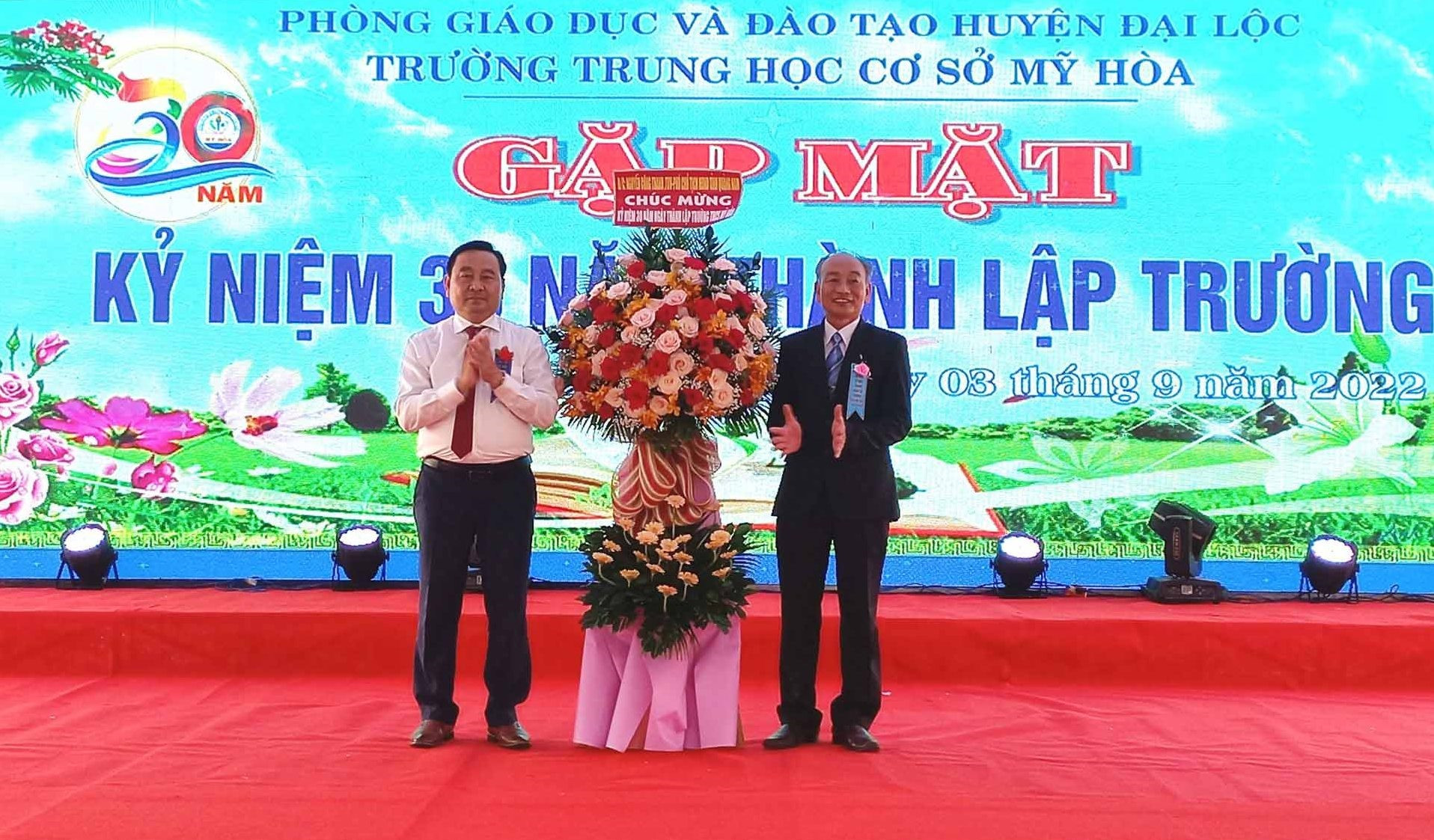 Phó Chủ tịch HĐND tỉnh Nguyễn Công Thanh (đứng bên trái) tặng lẵng hoa chúc mừng nhà trường. Ảnh: CT
