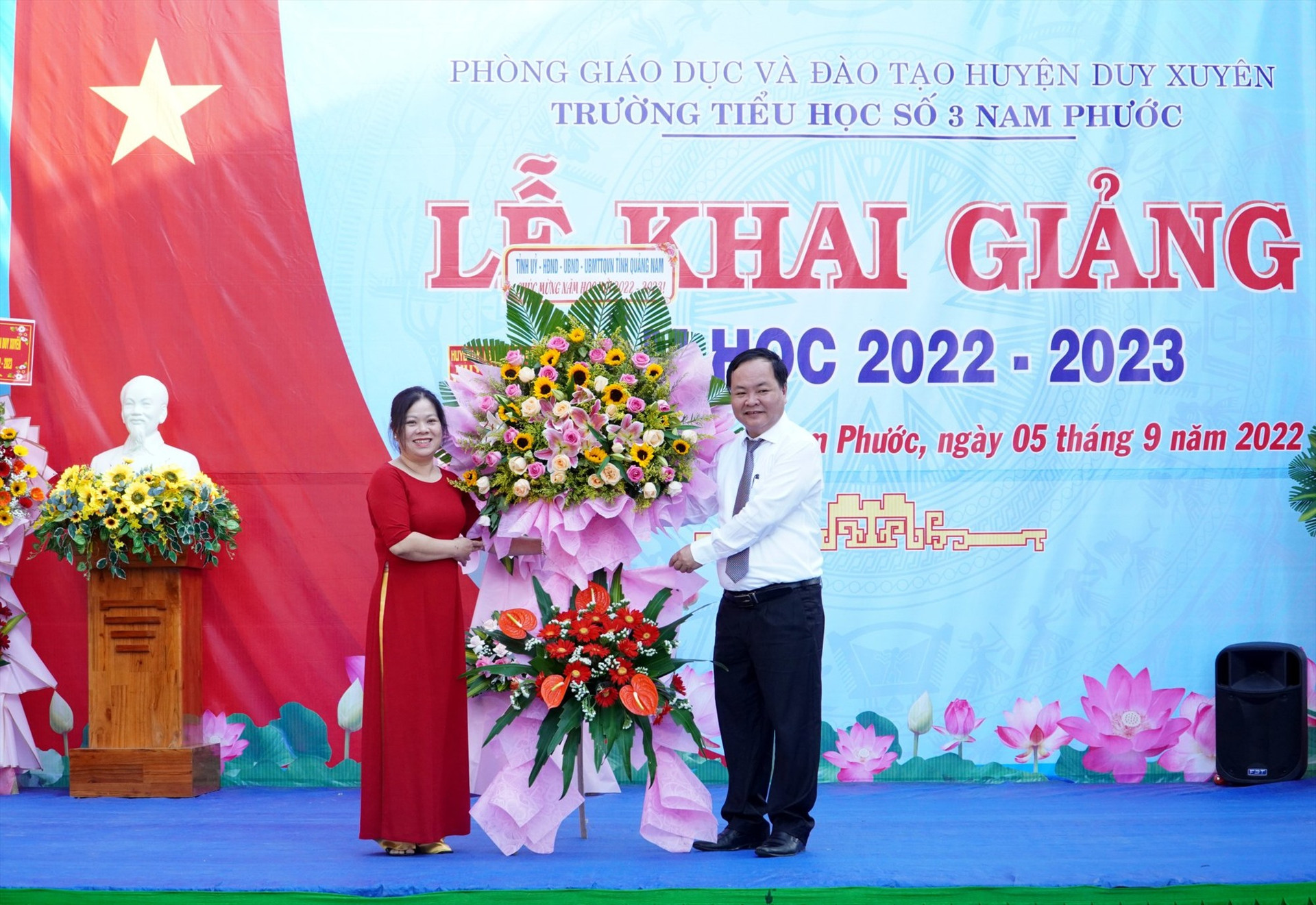 Phó Chủ tịch UBND tỉnh Nguyễn Hồng Quang tặng hoa chúc mừng lễ khai giảng trường Tiểu học số 3 Nam Phước. Ảnh: HỒ QUÂN