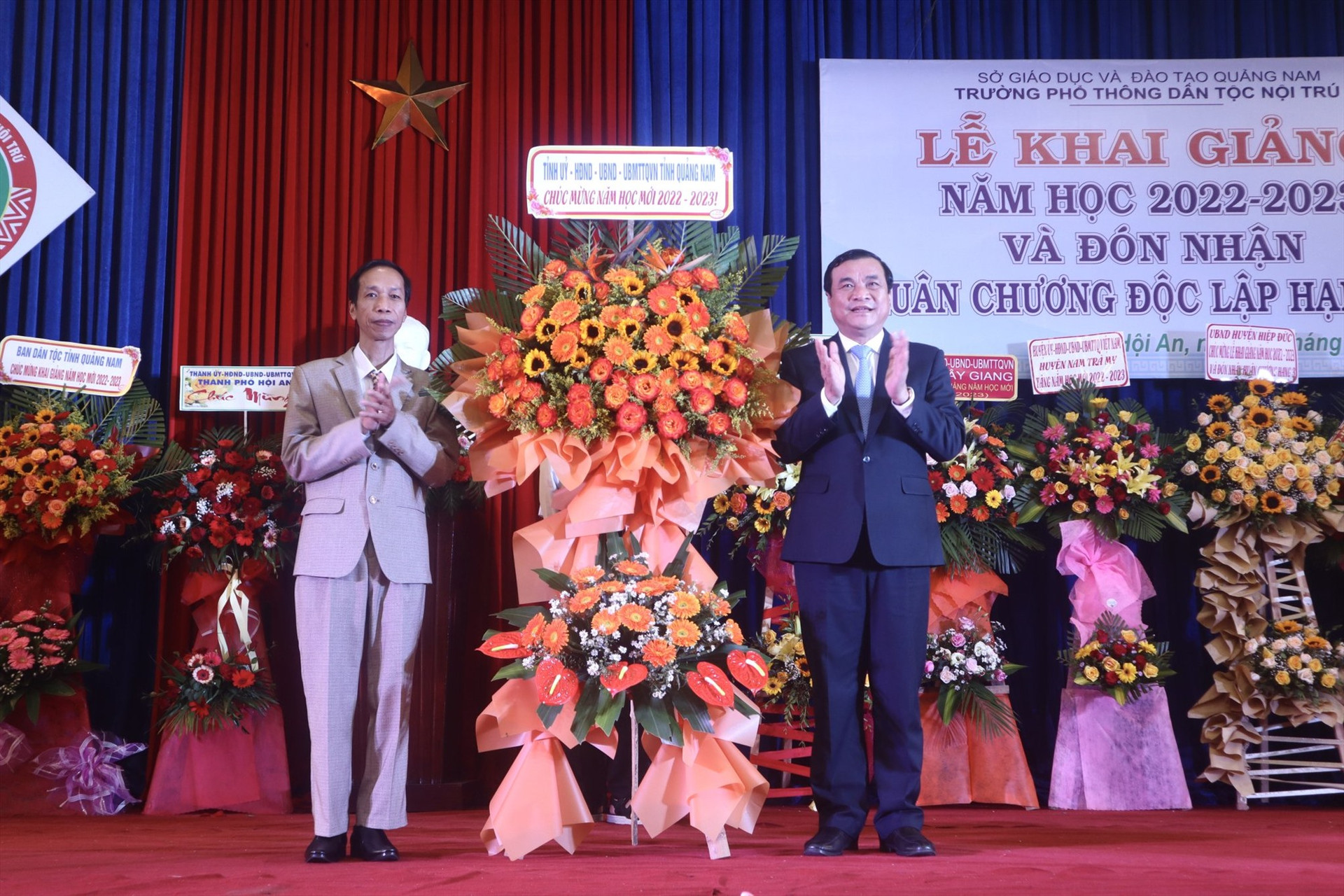 Đồng chí Phan Việt Cường tặng hoa chúc mừng năm học mới cho đại diện trường Phổ thông Dân tộc nội trú Quảng Nam. Ảnh: QUỐC TUẤN