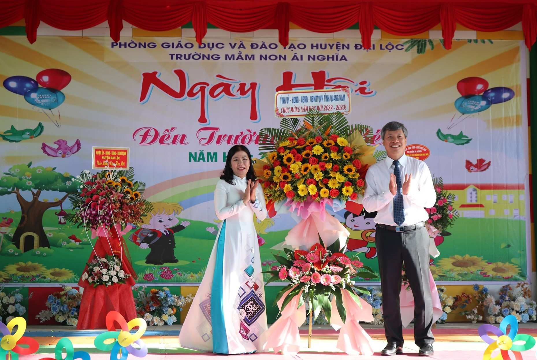 Phó Chủ tịch UBND tỉnh Hồ Quang Bửu tặng hoa chúc mừng Trường Mầm non Ái Nghĩa (Đại Lộc) nhân dịp khai giảng năm học mới. Ảnh: H.LIÊN