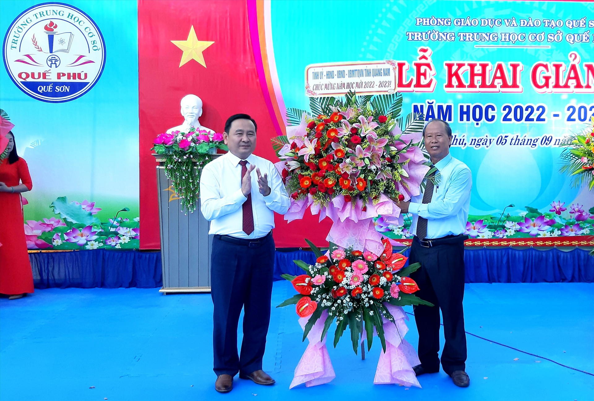 Phó Chủ tịch HĐND tỉnh Nguyễn Công Thanh tặng hoa chúc mừng thầy và trò Trường THCS Quế Phú. Ảnh: VĂN SỰ