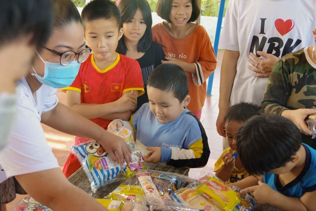 Thành viên Câu lạc bộ từ thiện Nguyễn Bỉnh Khiêm tặng bánh kẹo cho các em nhỏ vào dịp Tết trung thu. Ảnh: D.H