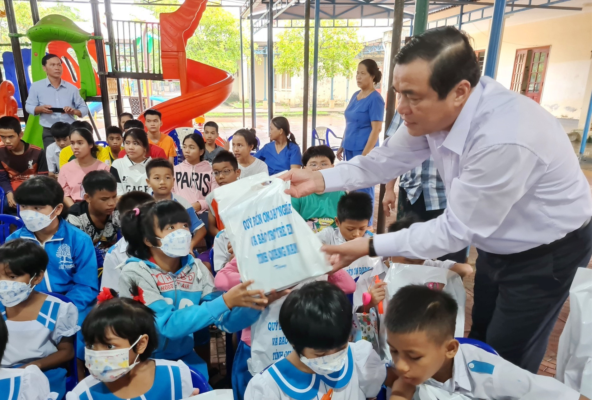 Bí thư Tỉnh ủy Phan Việt Cường tặng quà cho trẻ em Làng Hòa Bình. Ảnh: D.L
